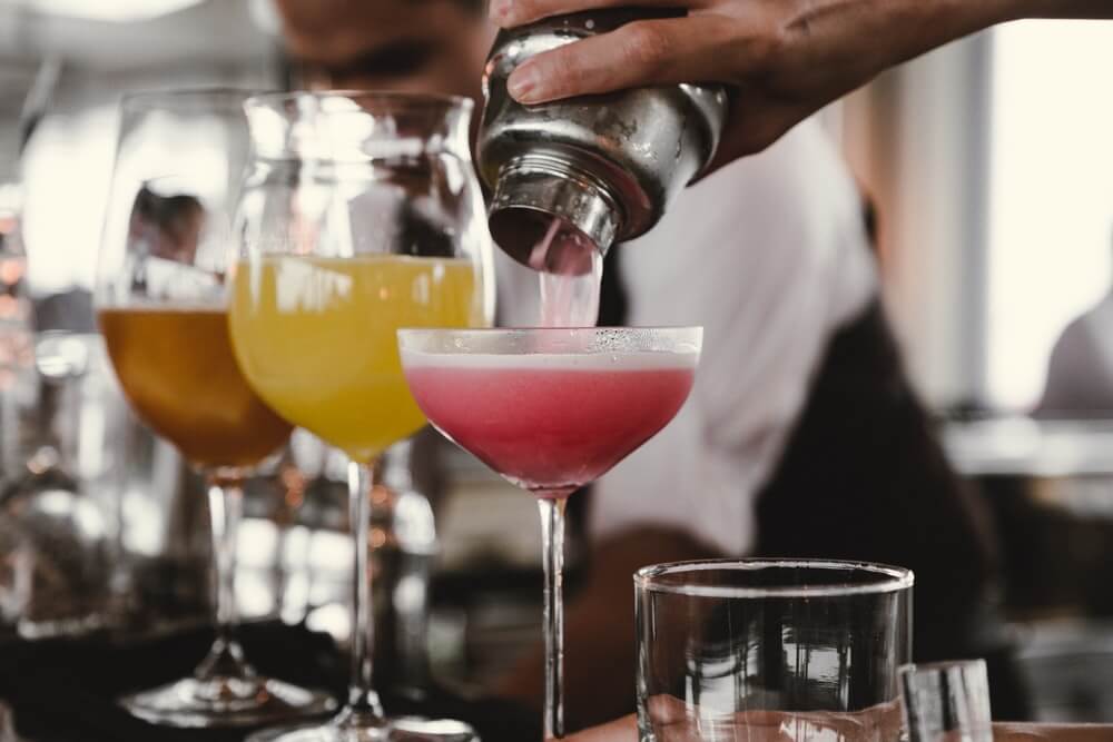 Pouring cocktails into different sized glasses