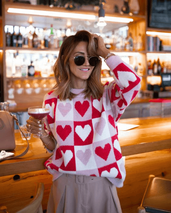 heart-knit sweater with a tan colored skirt