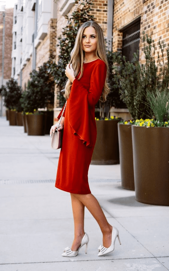 red bell sleeved knee length dress with a pair of white heels